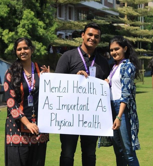 Students holding a sign reading Mental health is as important as physical health